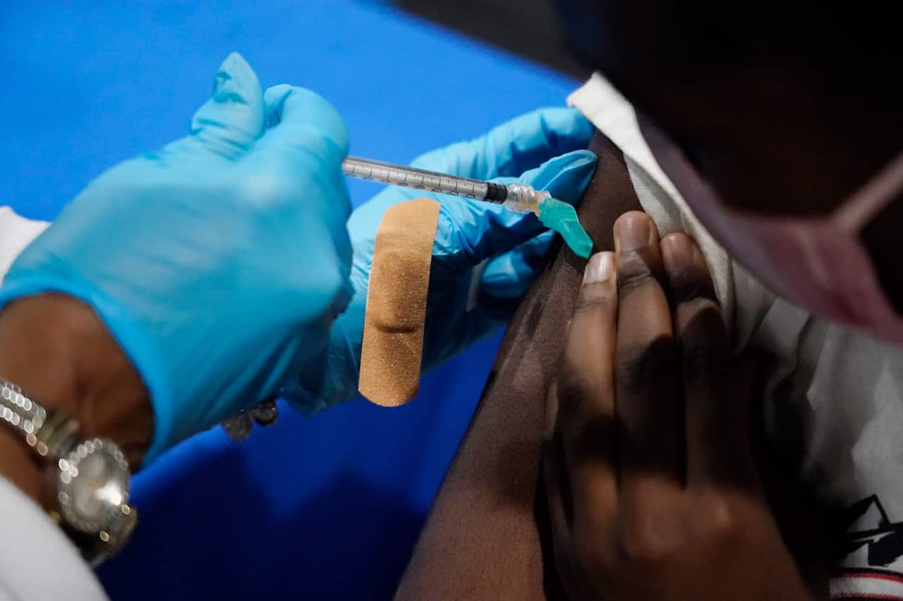 A nurse administers a dose of the Pfizer COVID-19 vaccine to a student