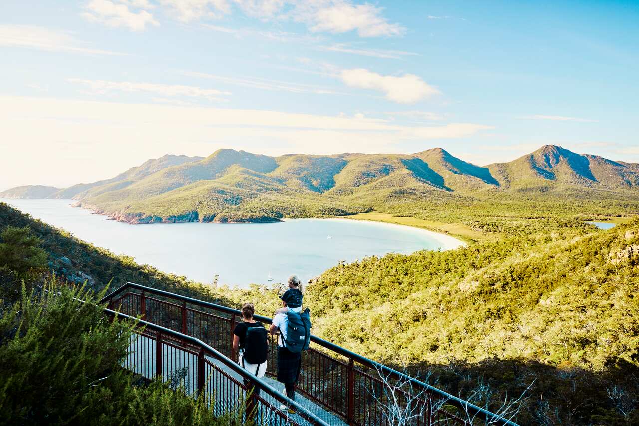 Worth the walk: Bushwalking young family in Tasmania, Australia taking in the view at Freycinet NP.
