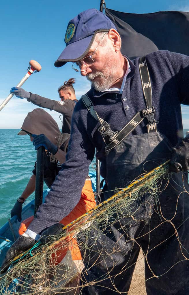 A man pulls up fishing net.