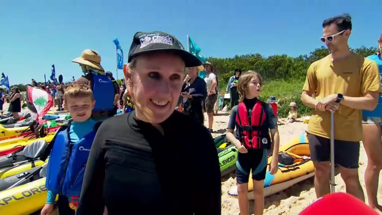 A woman speaking to a journalist.