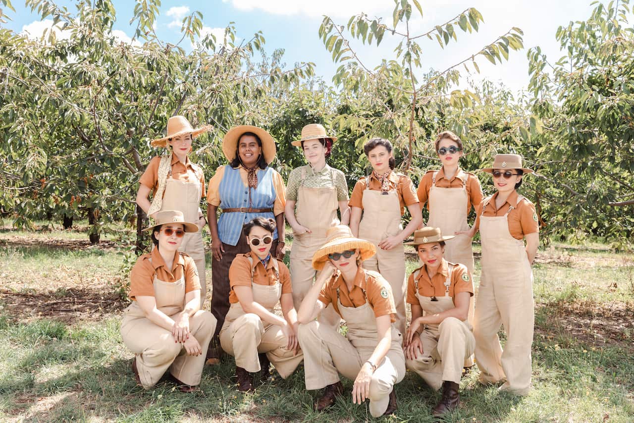 A group of women pose in an apple orchard