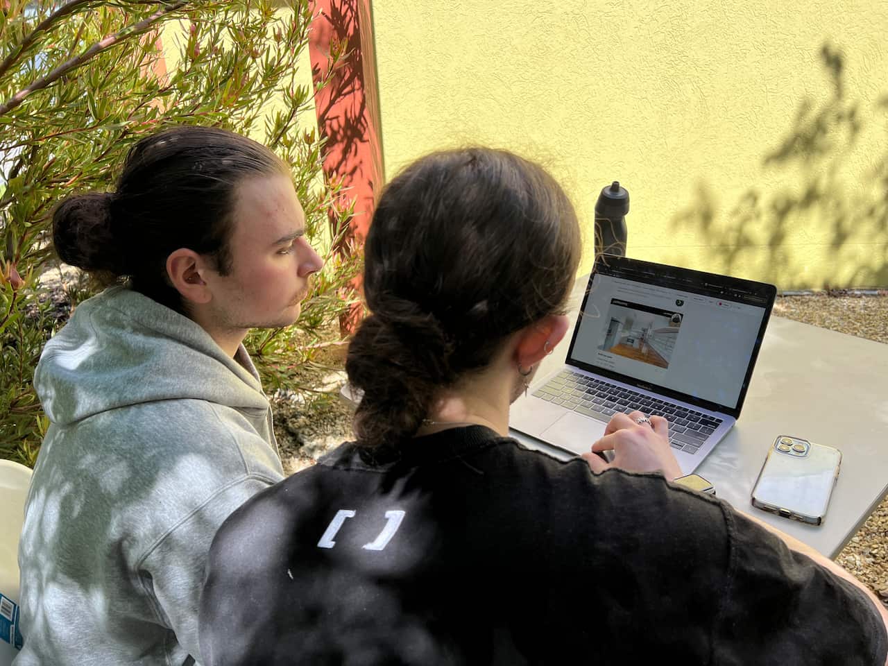 Two people looking at rental properties on a laptop