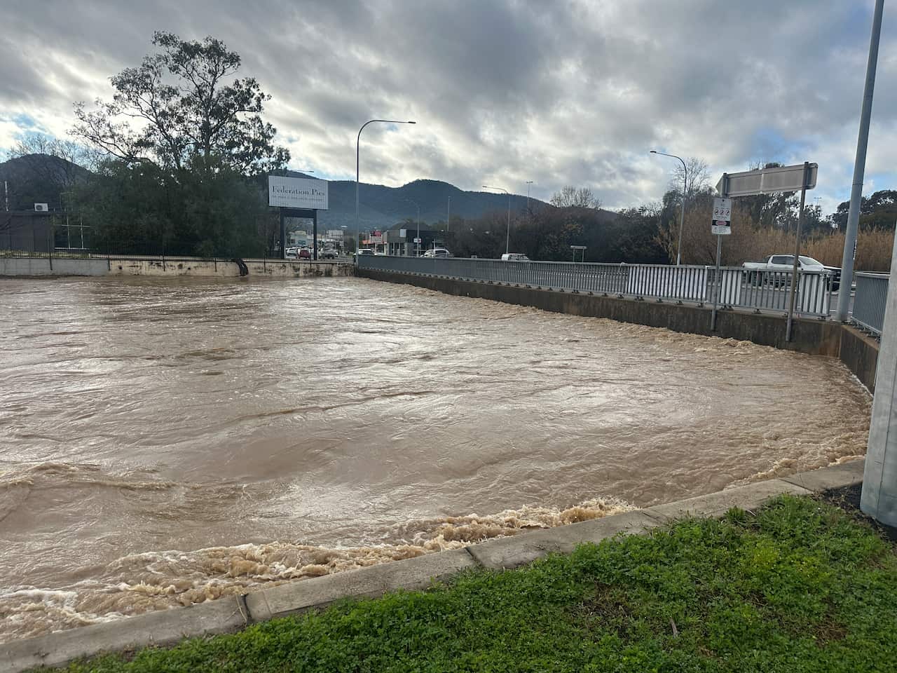 A flooded river near a road.
