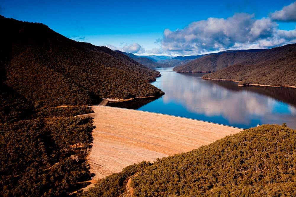 A dam with a narrow lake in the background