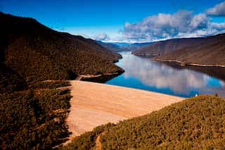 A dam with a narrow lake in the background