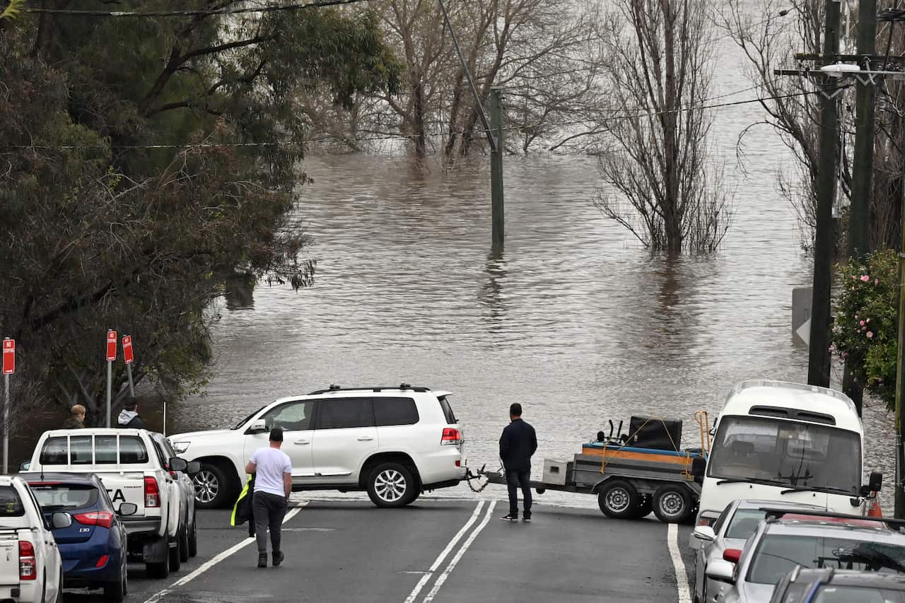 Flooded road with people waiting by
