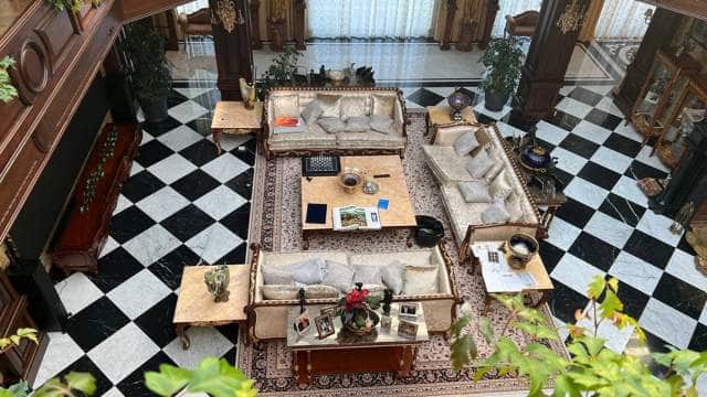 A grand-looking room with sofas, coffee tables, and ornate decorative pieces.