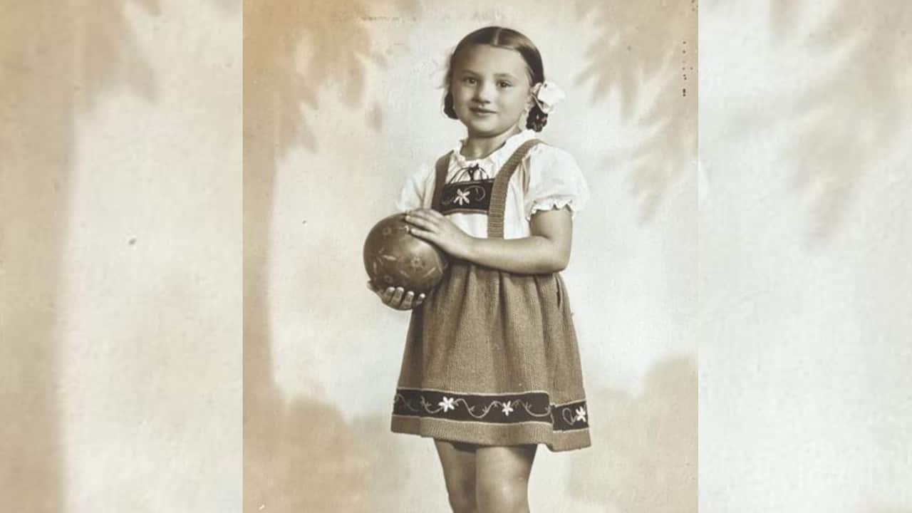a sepia image of a young girl in an European smock and hair in braids
