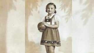 a sepia image of a young girl in an European smock and hair in braids