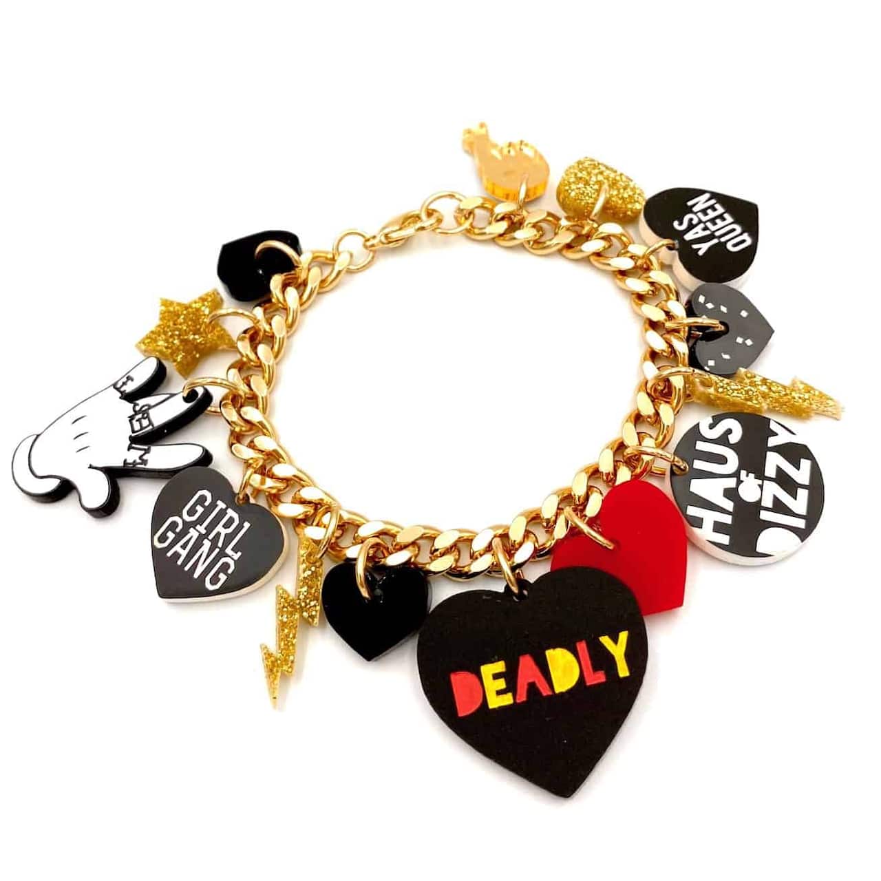 A gold bracelet with lots of charms on it, including a love heart with deadly written on it in the aboriginal flag colours. 