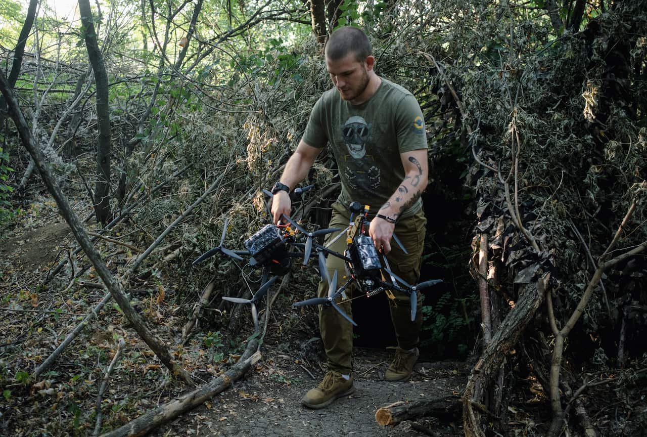 Ukrainian pilot holding drones ready to launch for an attack.