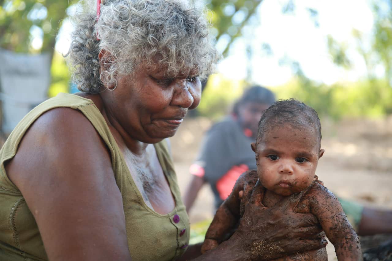 Our Medicine. Baby covered in clay for strengthening ceremony. NITV, SBS.jpg
