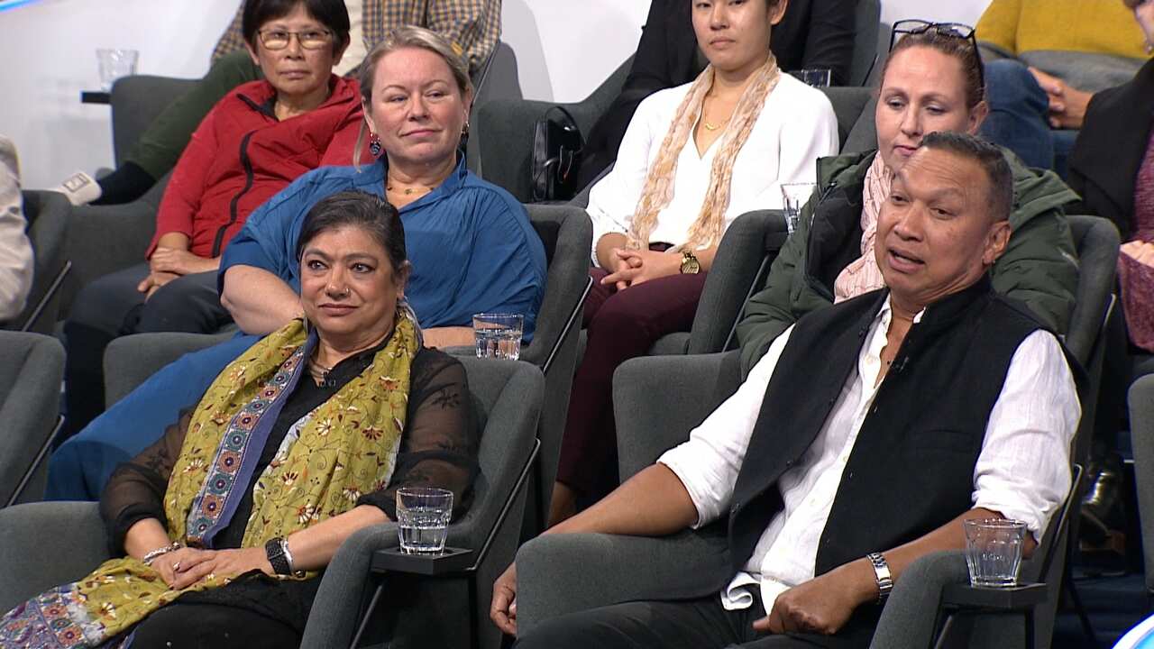 A man and a woman talk in a TV studio.