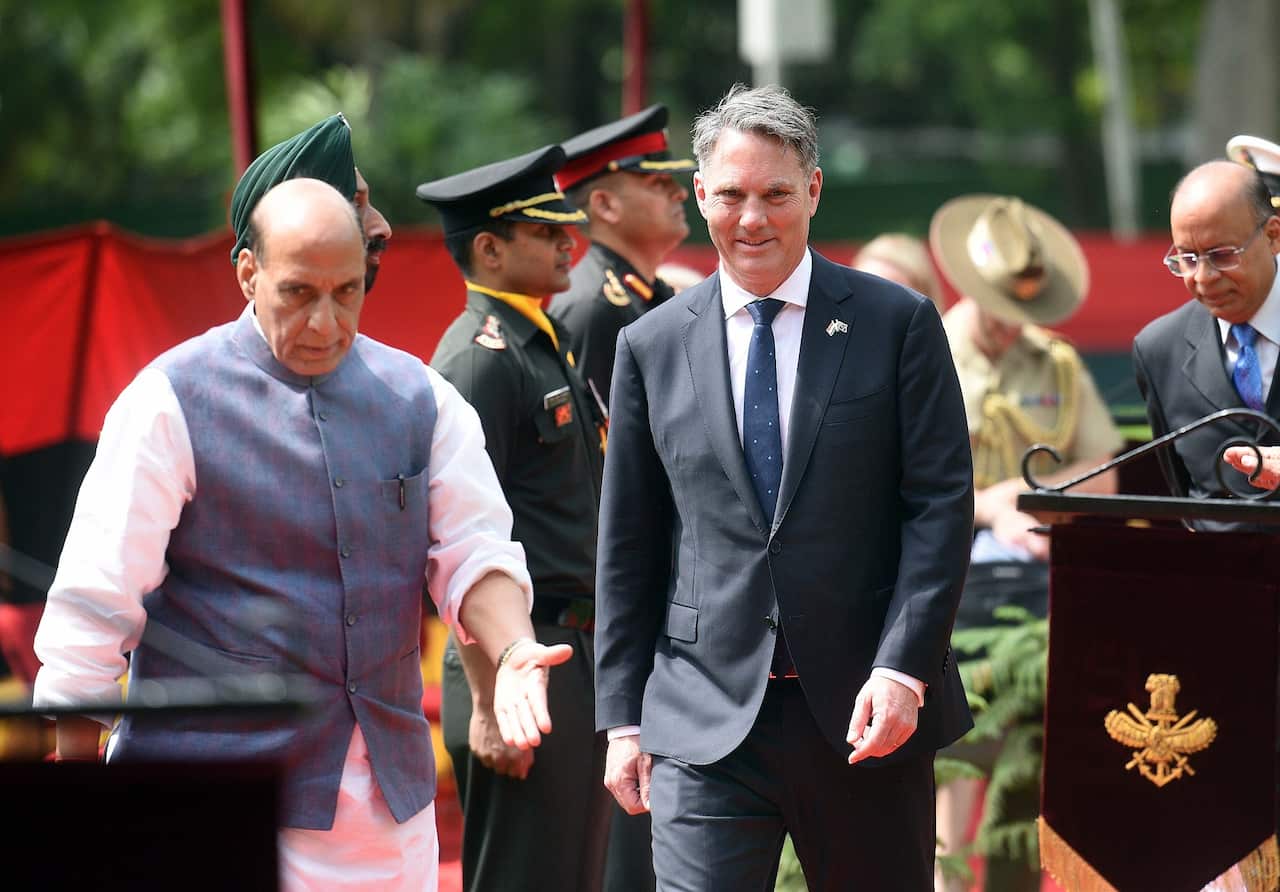 Defence Minister Rajnath Singh and Australian Defence Minister Richard Marles walk past a military guard of honour.