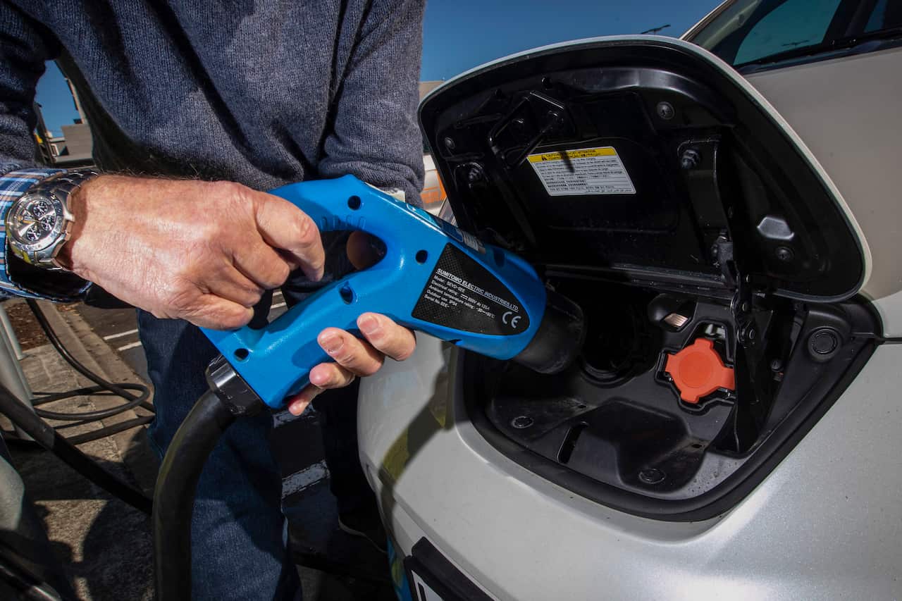 A person charges an electric vehicle