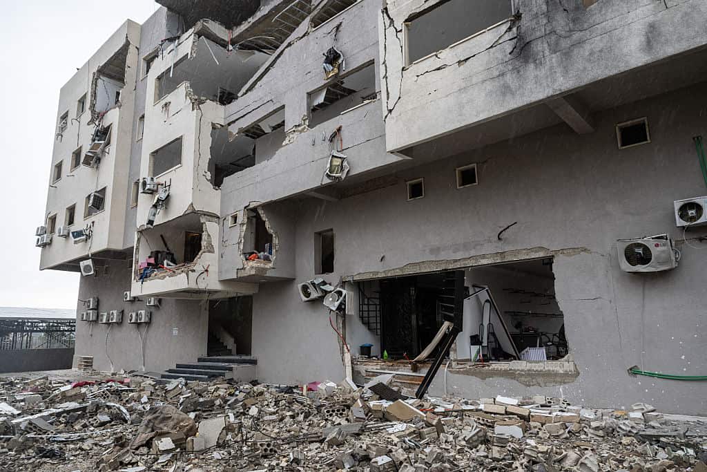 A bombed out apartment block stands in ruins.