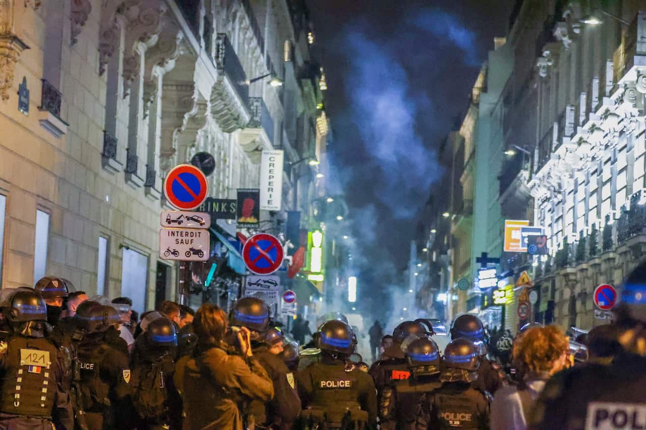 Police populate the streets of Paris at night.