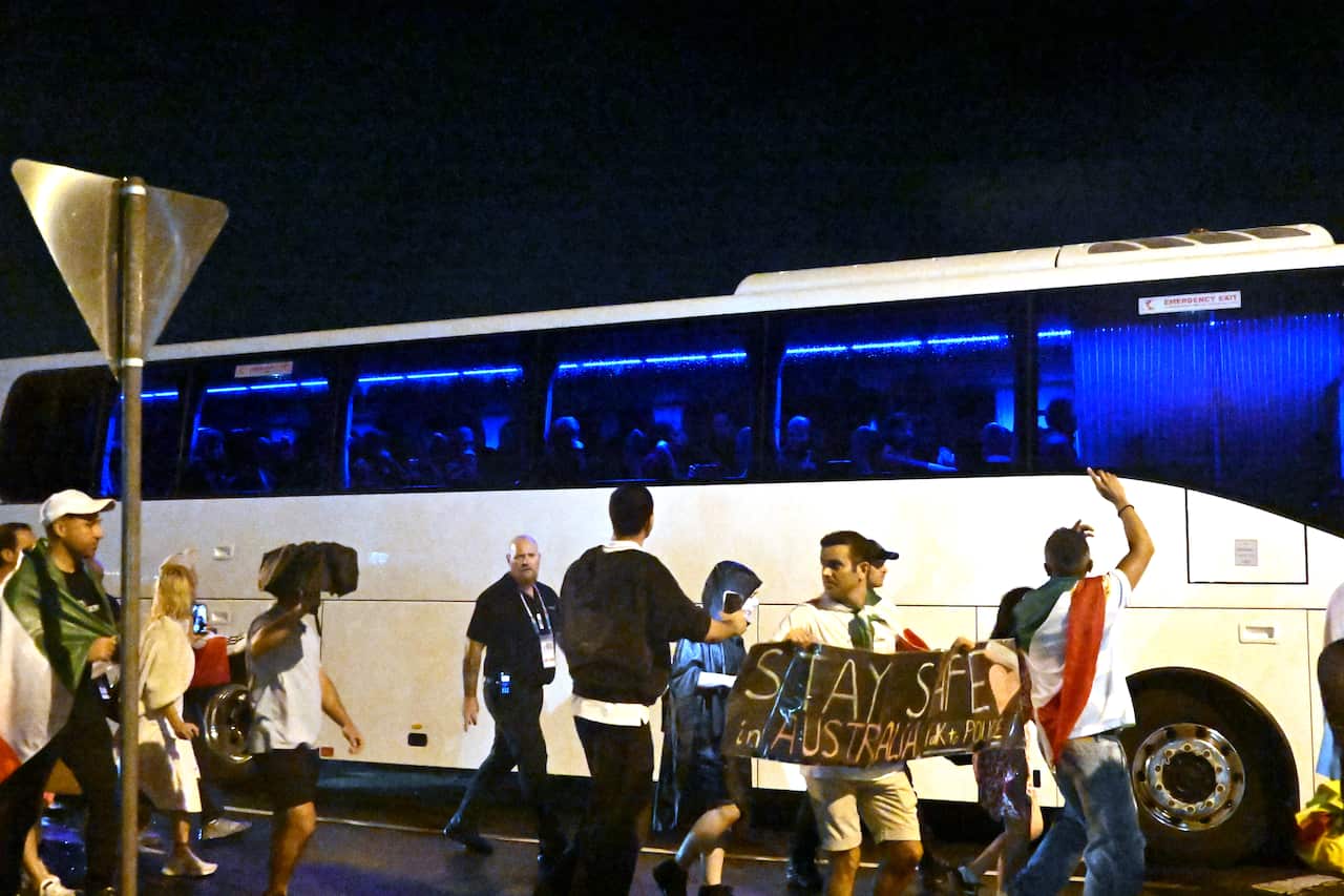 A group of protesters are seen around a bus transporting football players after a match.