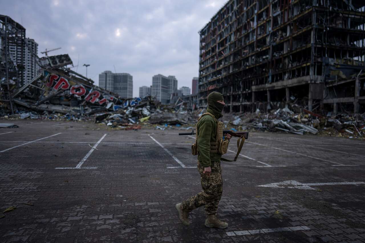 A soldier walks past a destroyed shopping centre.