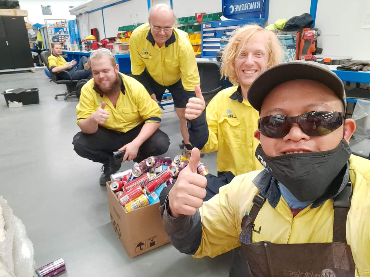 Archie Caadan with co-workers sharing their containers for the charity in Philippines.JPG