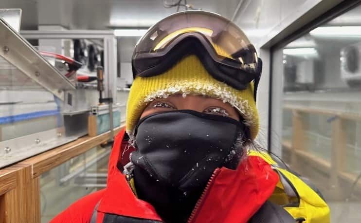 Icicles coat a woman's eyelashes and beanie