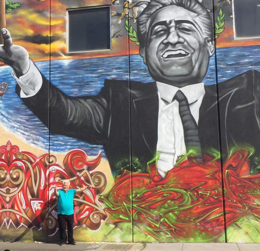 A mural showing a man in a suit with his arms outstretched. 