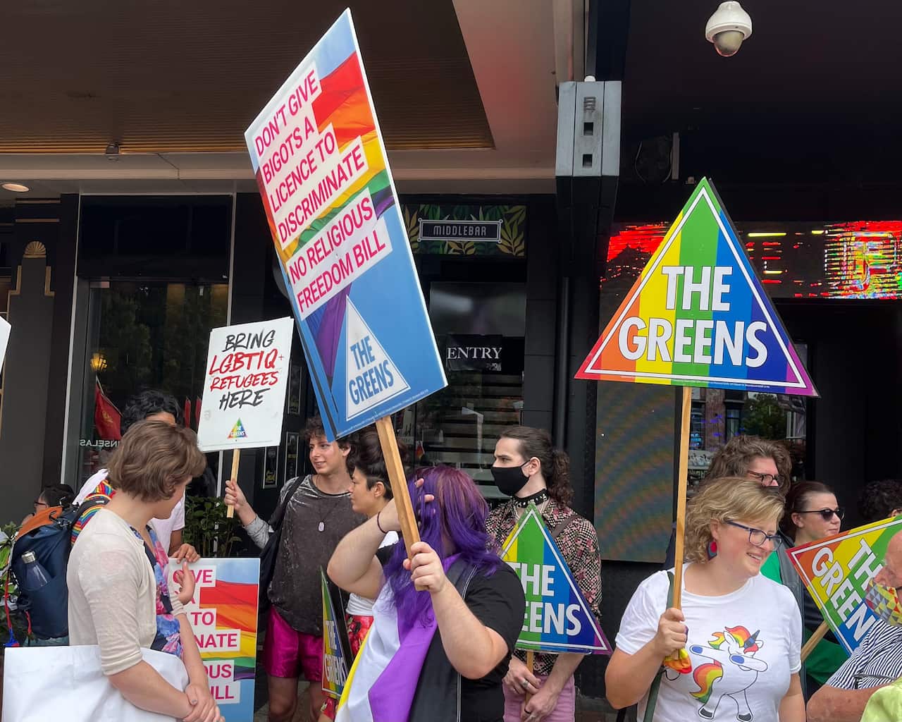 The Greens Party supporters and volunteers holding rainbow political party signs