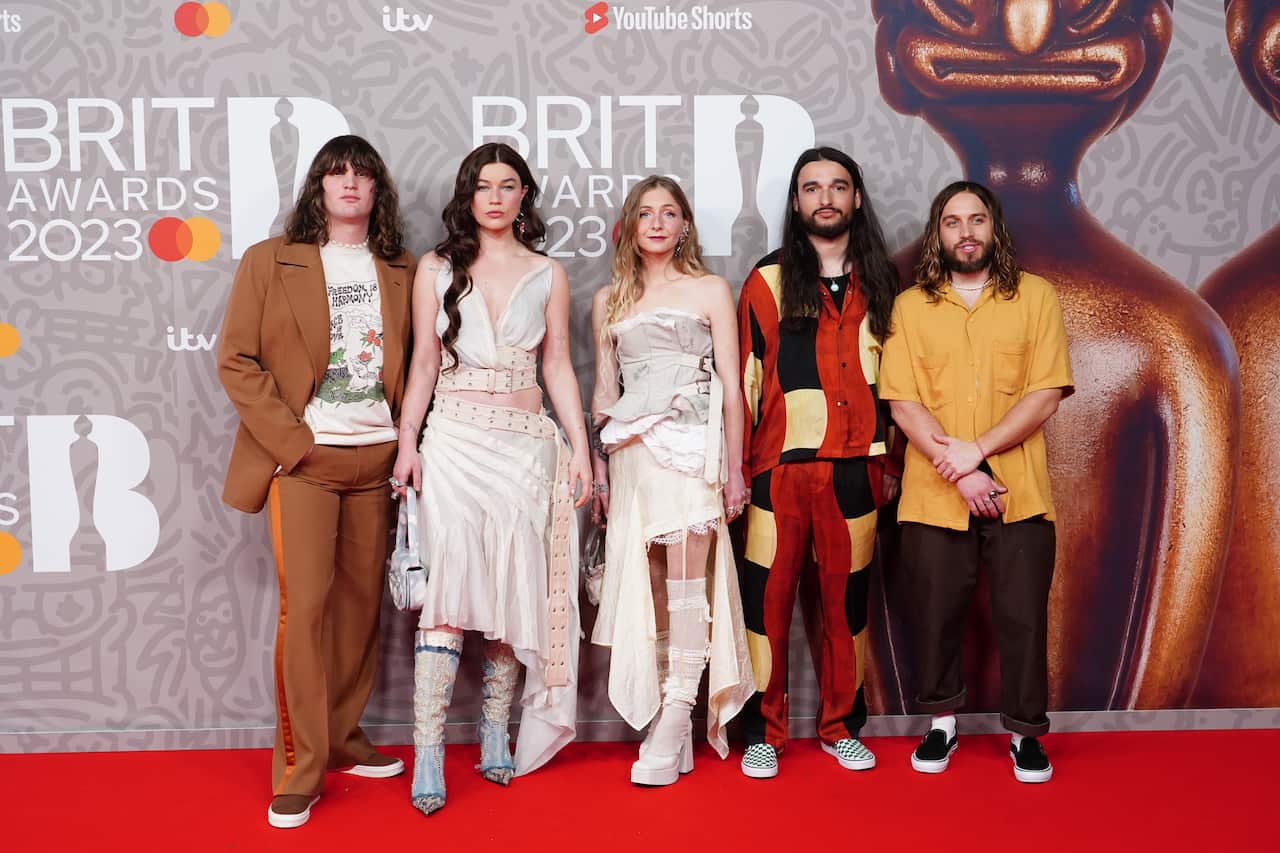 A group of three men and two women on the Brit Awards red carpet