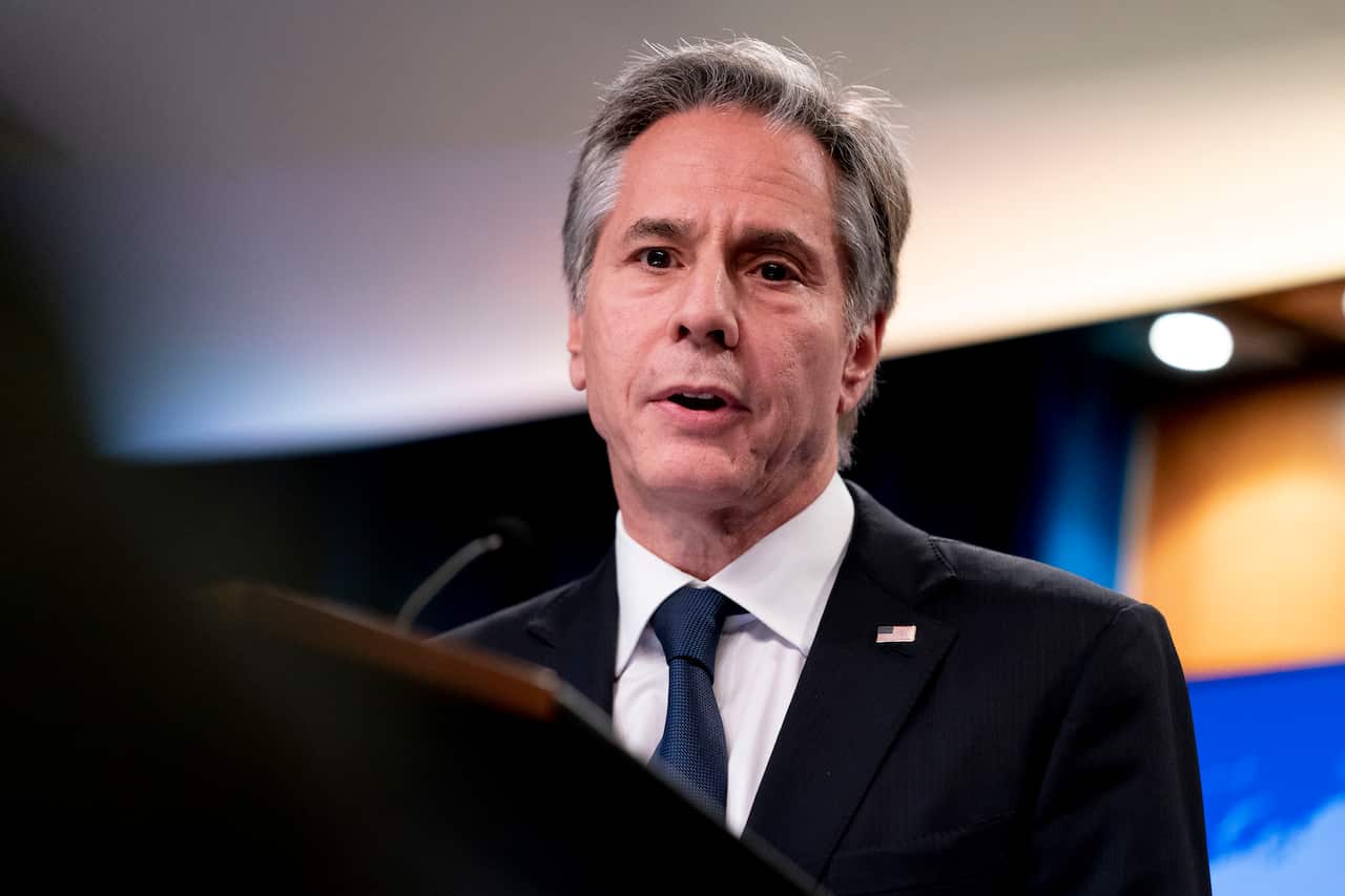 A man wearing a suit and tie who is standing at a lectern and speaking.