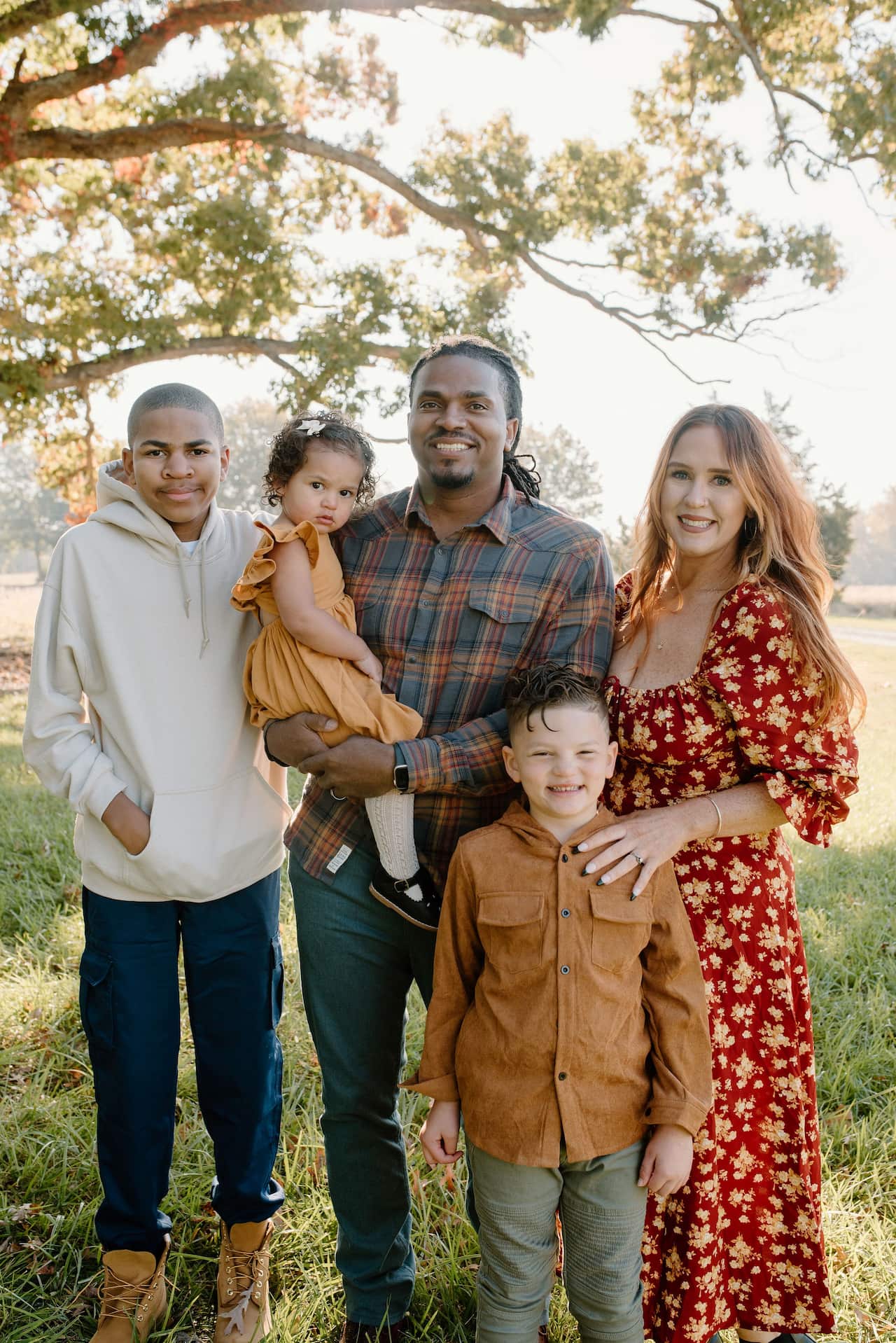 A family stand for a portrait in a field.