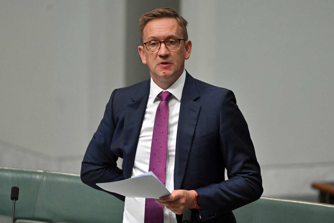 A man in a suit talking in parliament.