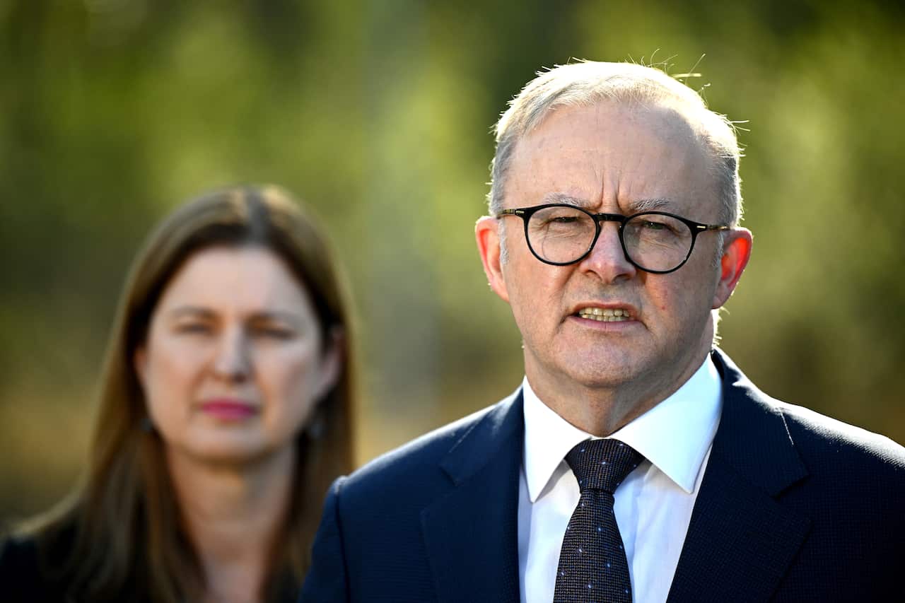 Man in suit and glasses talking.