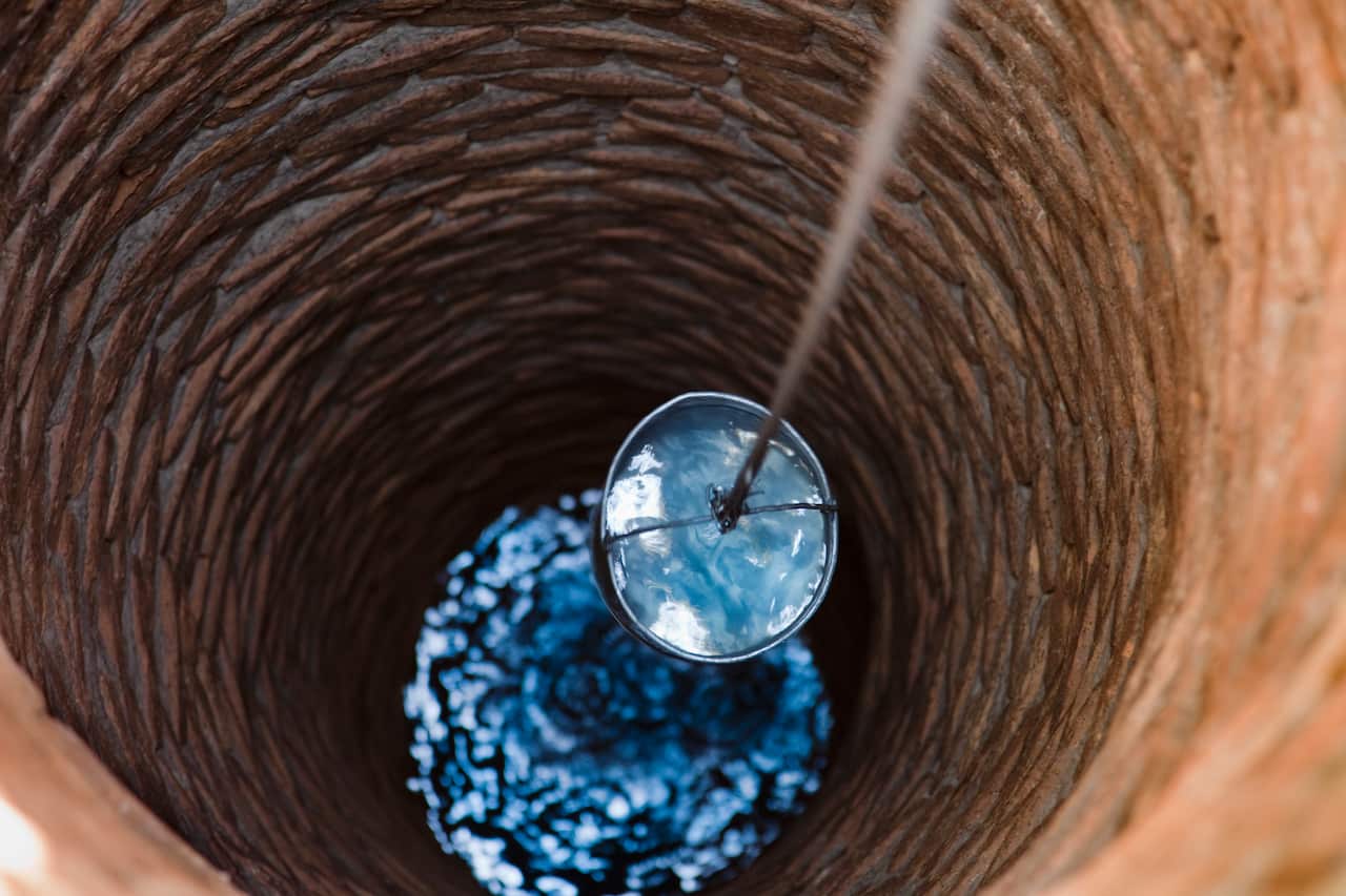 Water bucket being raised from a well