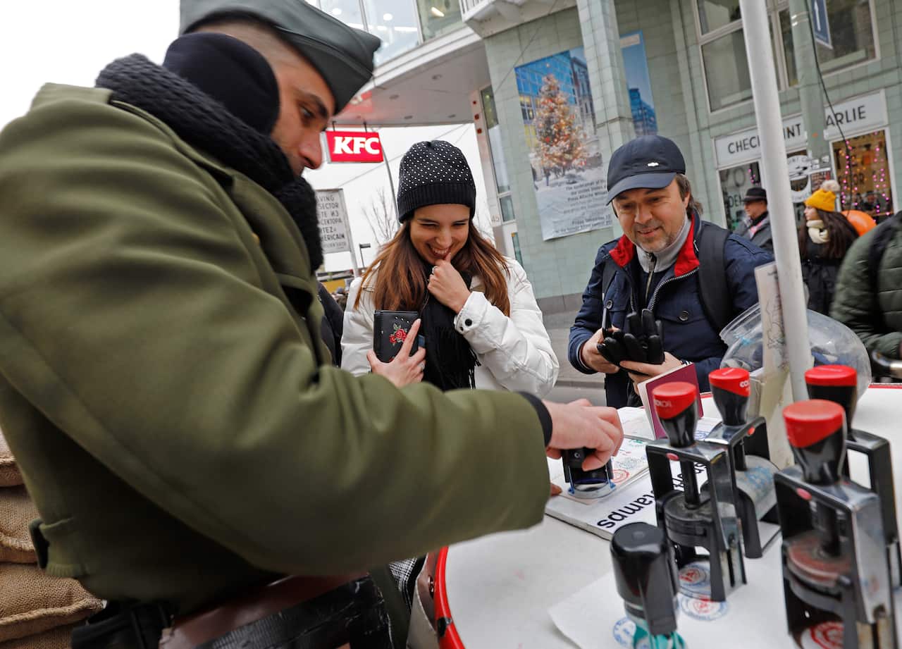 Tourists at Checkpoint Charlie having their passports stamped.