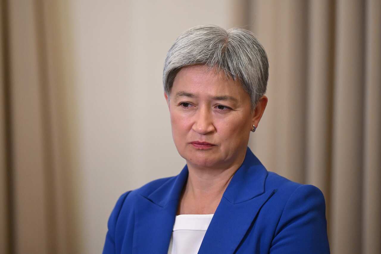 A woman with grey hair, wearing a blue suit. 