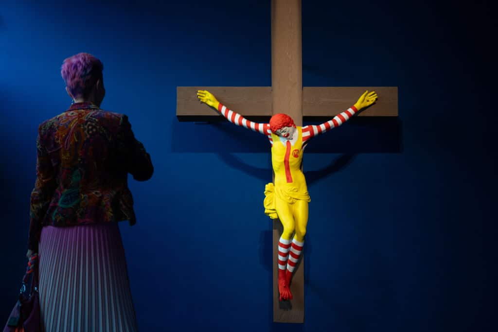 A sculpture showing cartoon character Ronald McDonald being crucified on the cross.