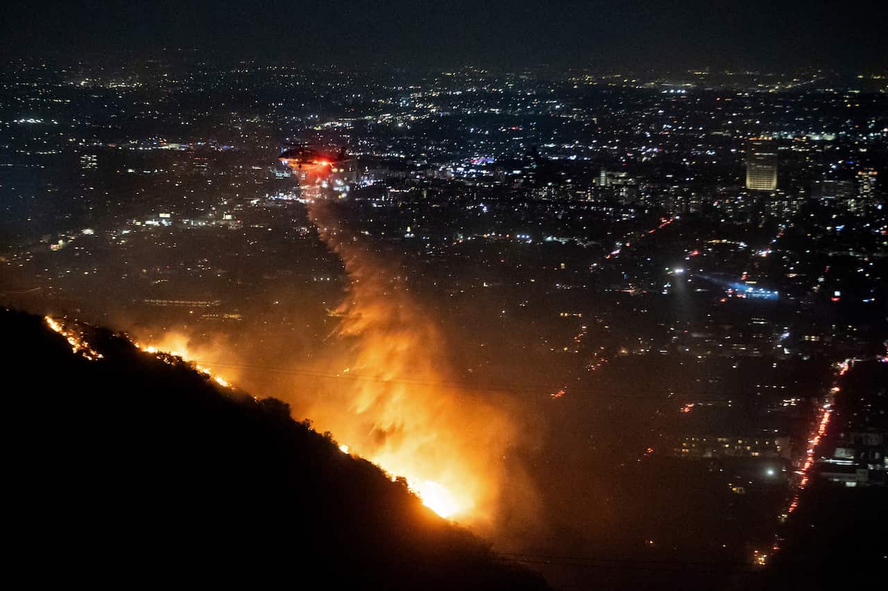 Water is dropped by helicopter on a wildfire. 