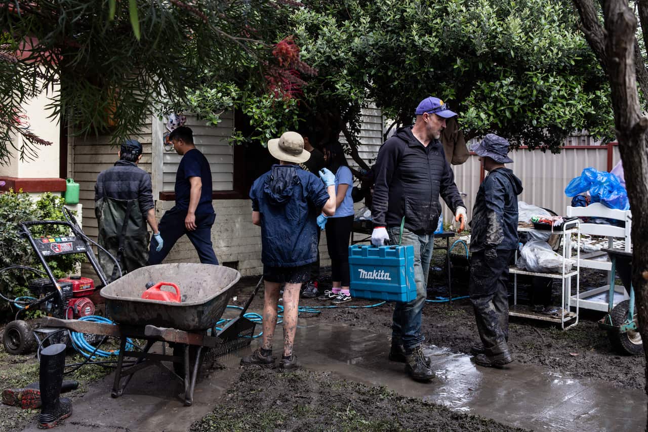 People taking part in a clean up effort at home that has been affected by floodwater.