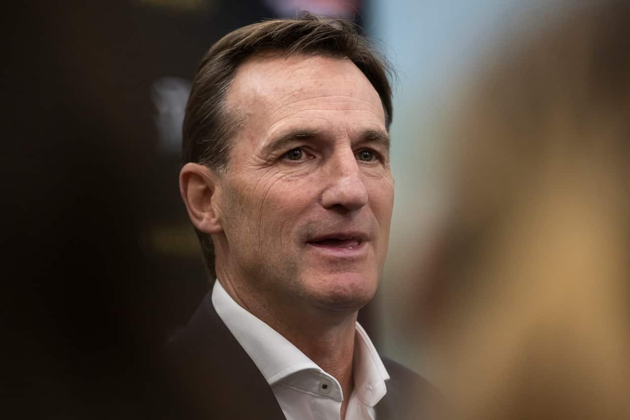 A close-up of a man in a suit speaking.