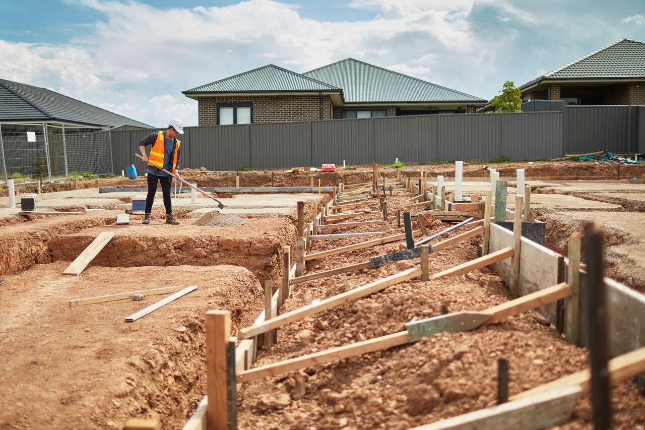 A worker in hi-vis clothing at a building site.