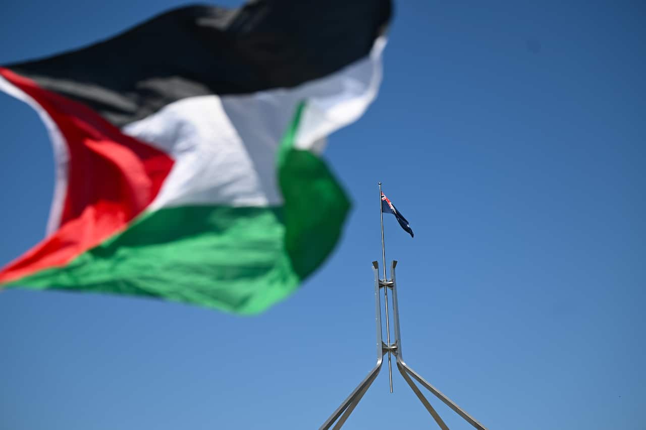 A Palestinian flag flies next to the Australian flag on top of Parliament House.