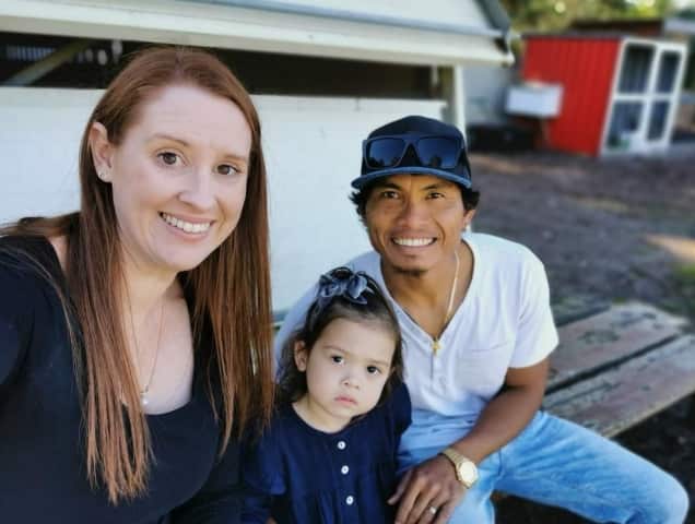 (left to right) A woman, a small girl and a man sitting on a bench. 