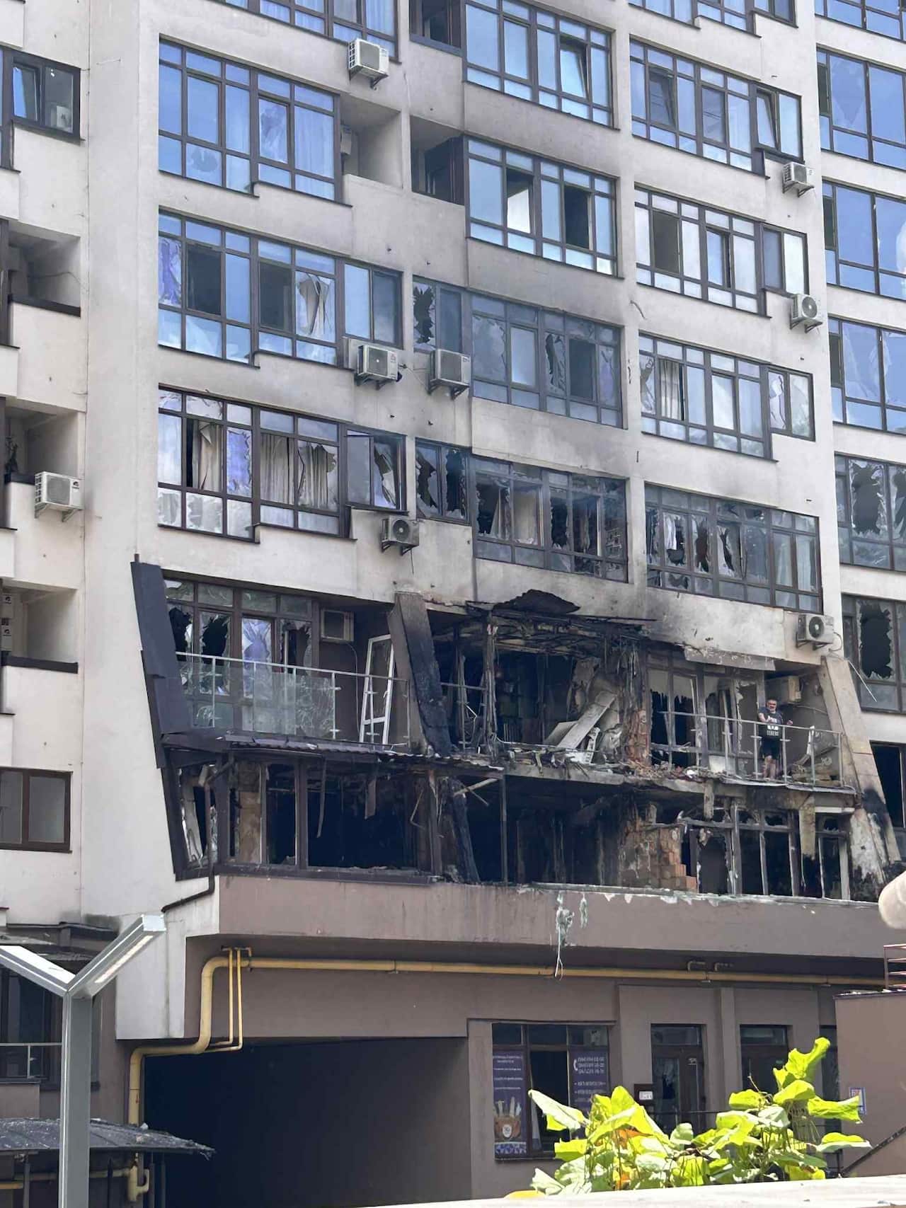 A bombed-out building with shattered windows and charred marks on the bottom two floors.