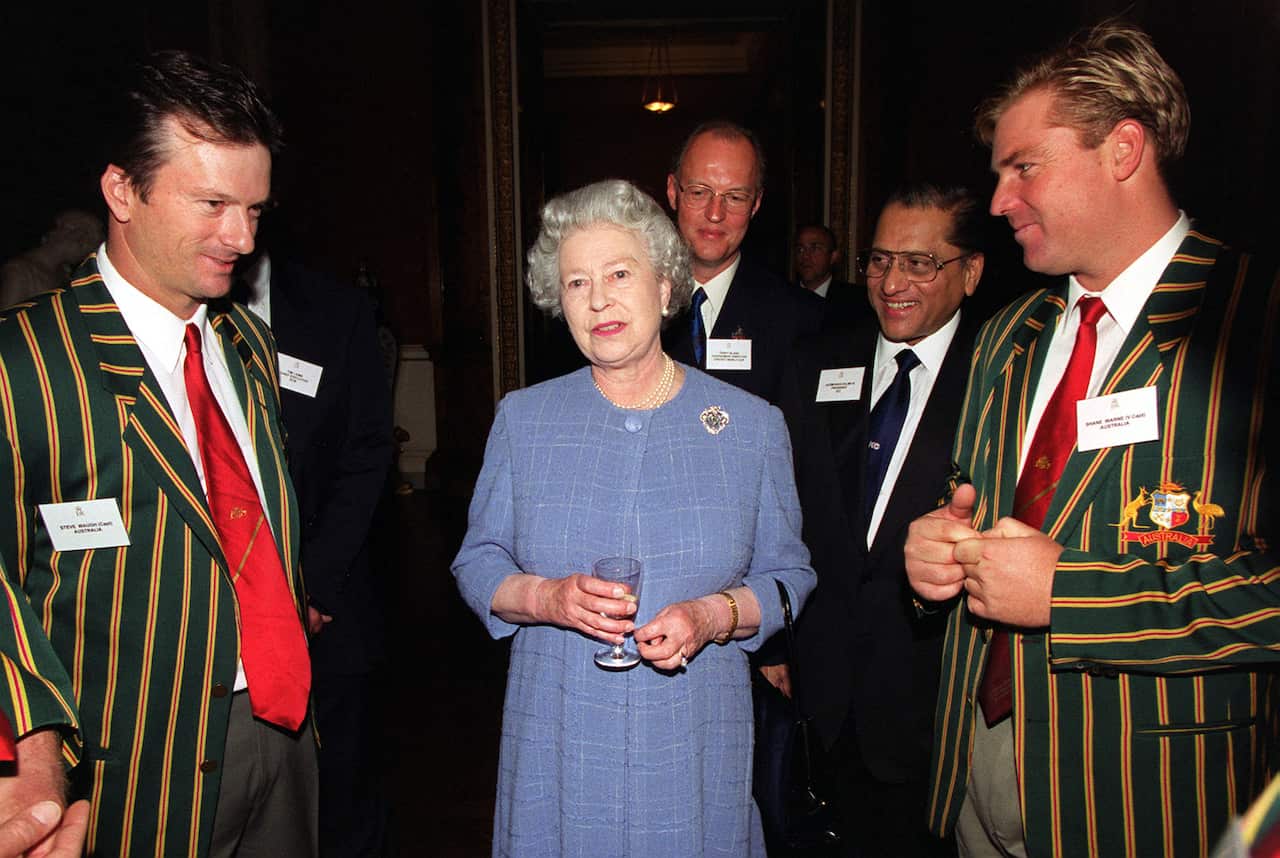 Queen Elizabeth II is seen with Shane Warne and Steve Waugh standing either side of her.