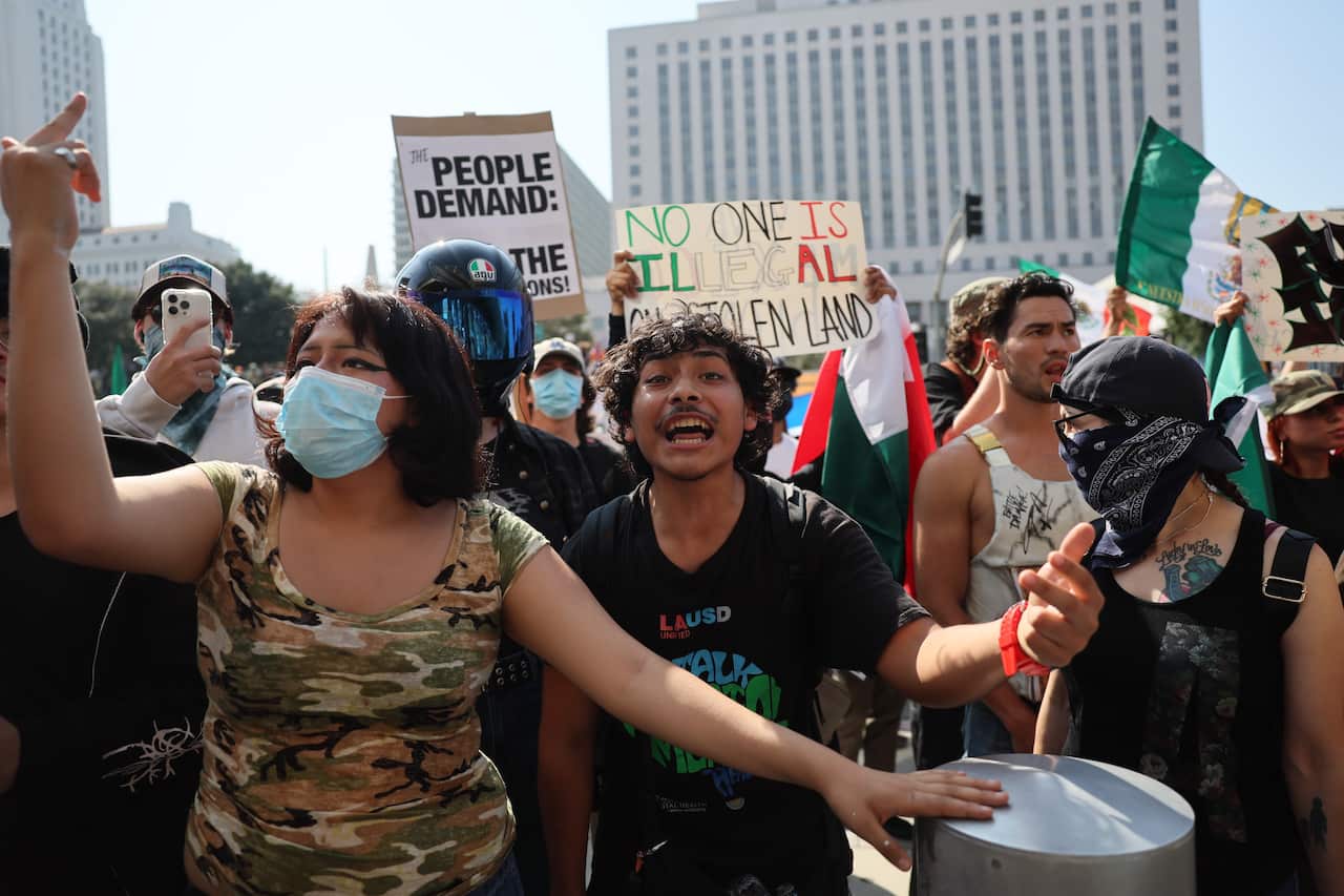 A group of protesters demonstrating, some holding signs.
