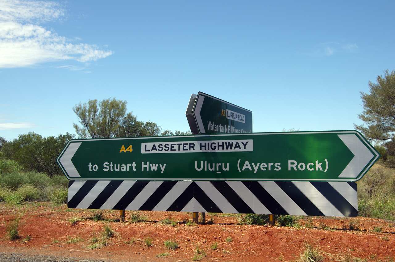 Road signs on the T-intersection of Lasseter Highway with Luritja Road, Northern Territory, Australia