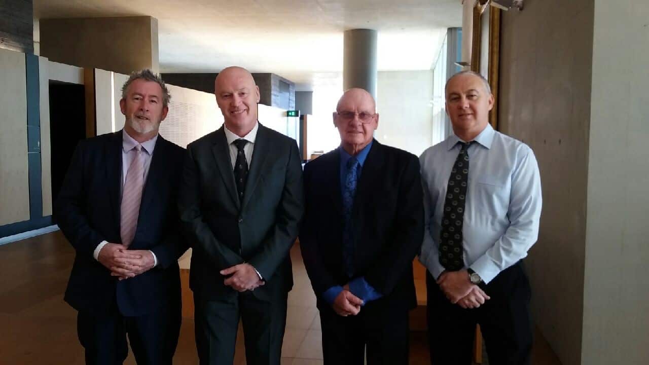 Darryl with his biological father Allen and two brothers before his adoption discharge case in Brisbane.