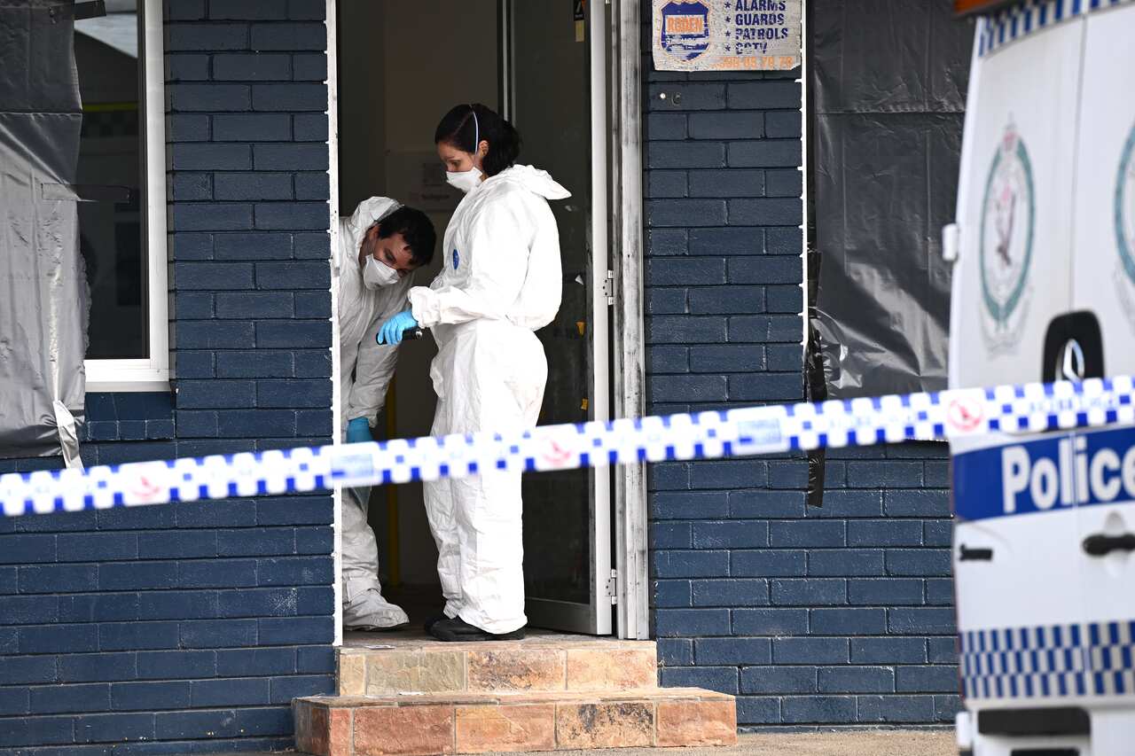 Forensic investigators examining a doorway.