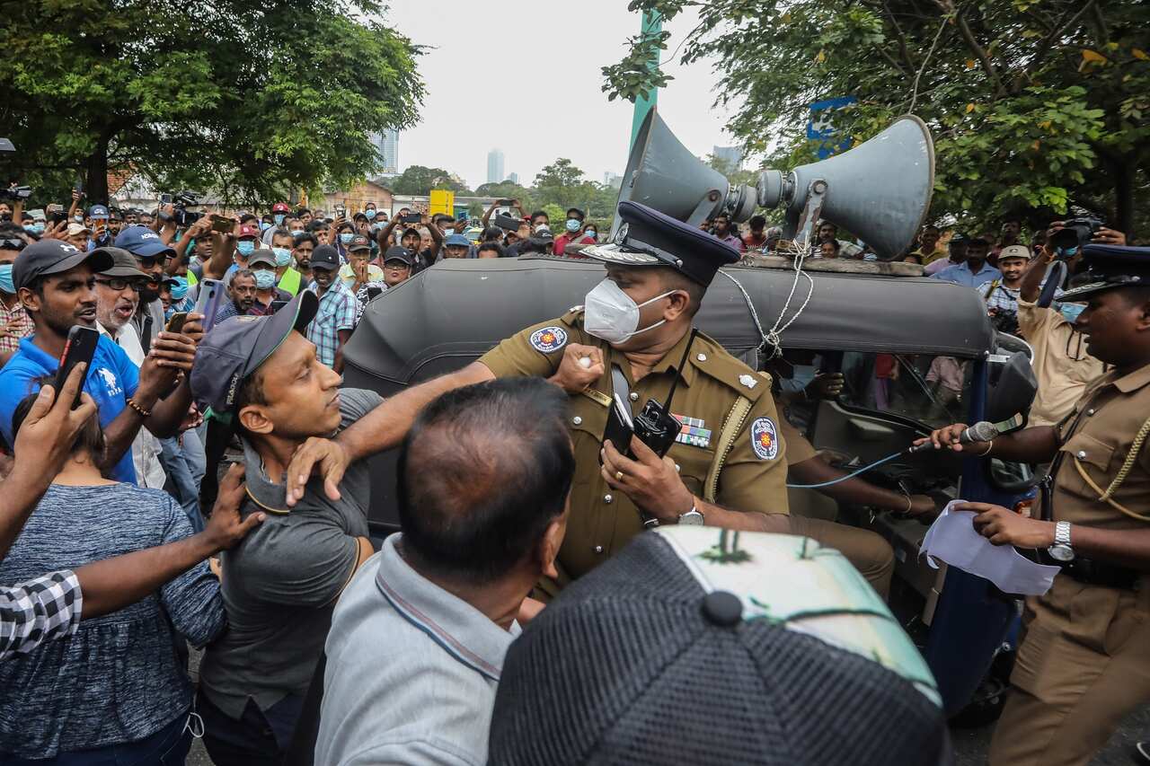 A police officer is pictured in the middle of a crowd of protesters.  