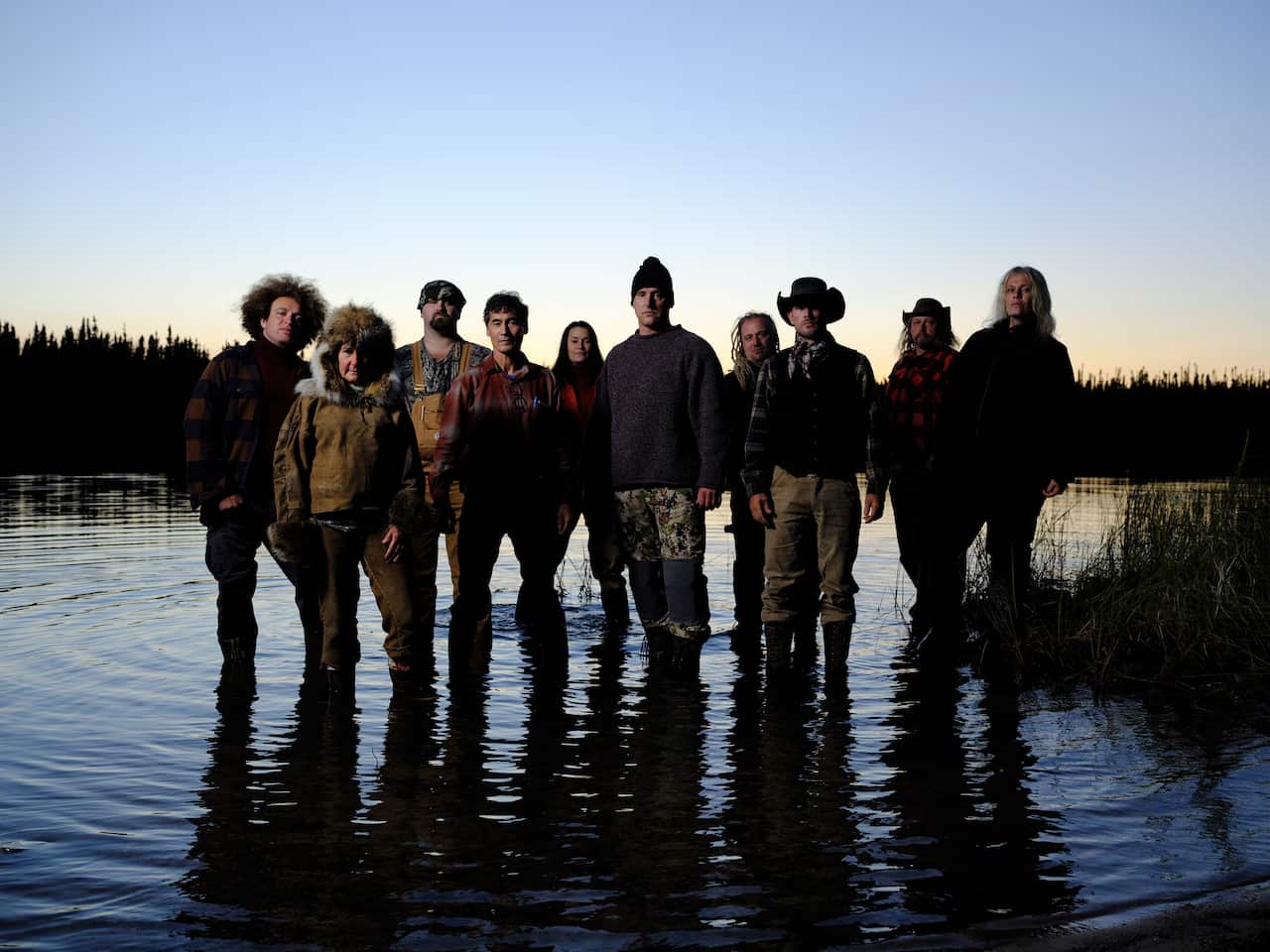 10 Alone season 10 participants stand in shallow water